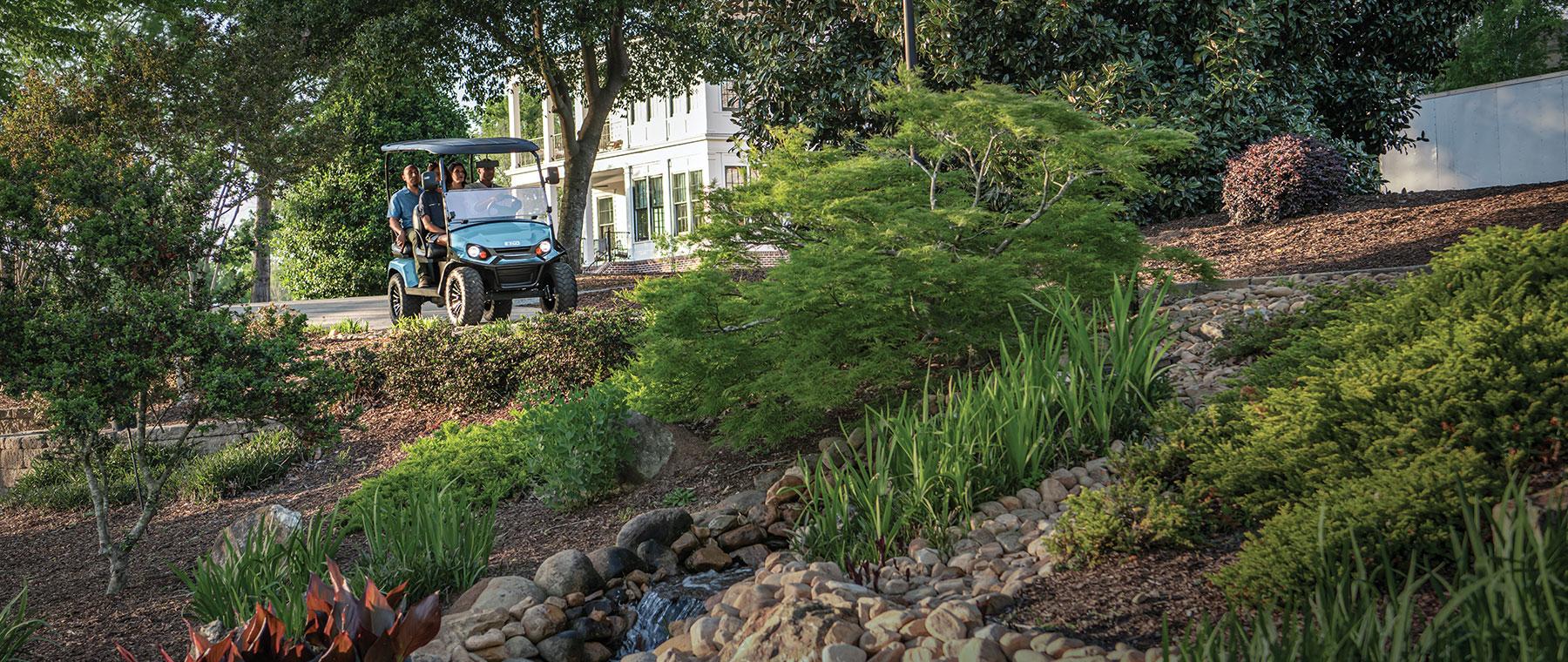 people on golf cart driving through neighborhood